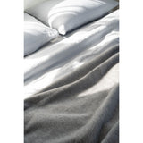 Gray comforter on a bed with pillows