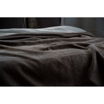 Brown textured blanket on a surface with a neutral background